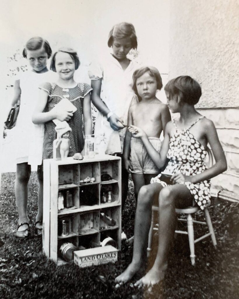 old black and white photo of five little girls playing store outside