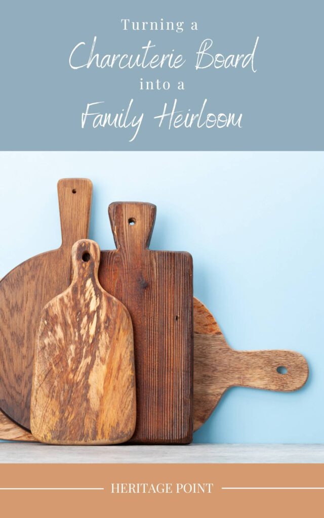 Four wooden charcuterie or cutting boards stacked together and leaned against a blue wall